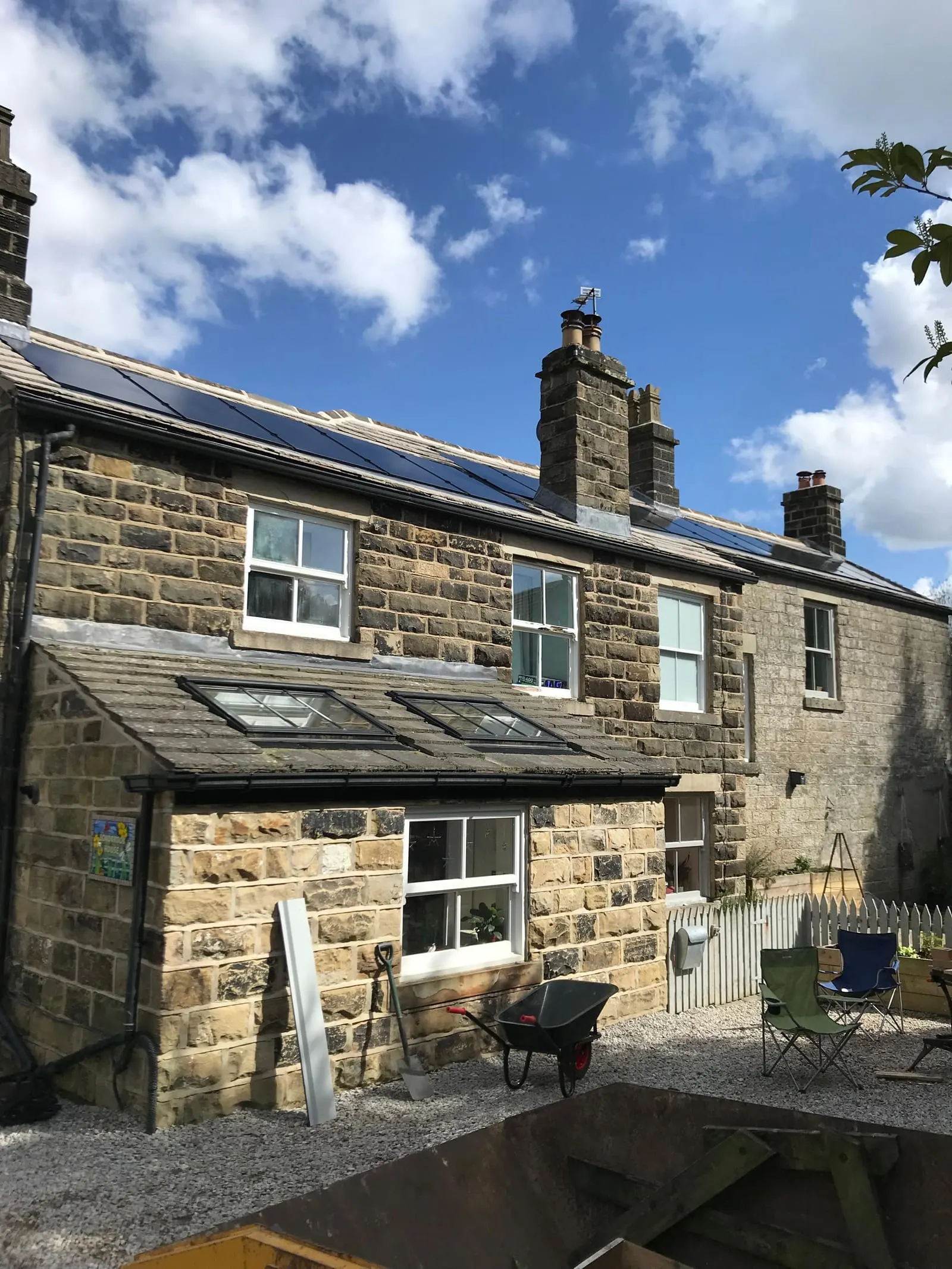 The Yorkshire stone house seen from the garden, with the solar array on the slate roof